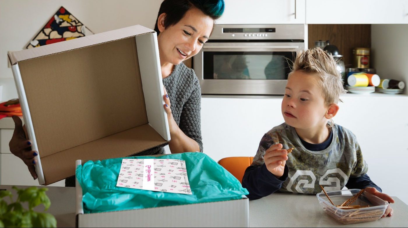 Mantelzorger pakt samen met zoontje verwenbox van HandicapNL uit.
