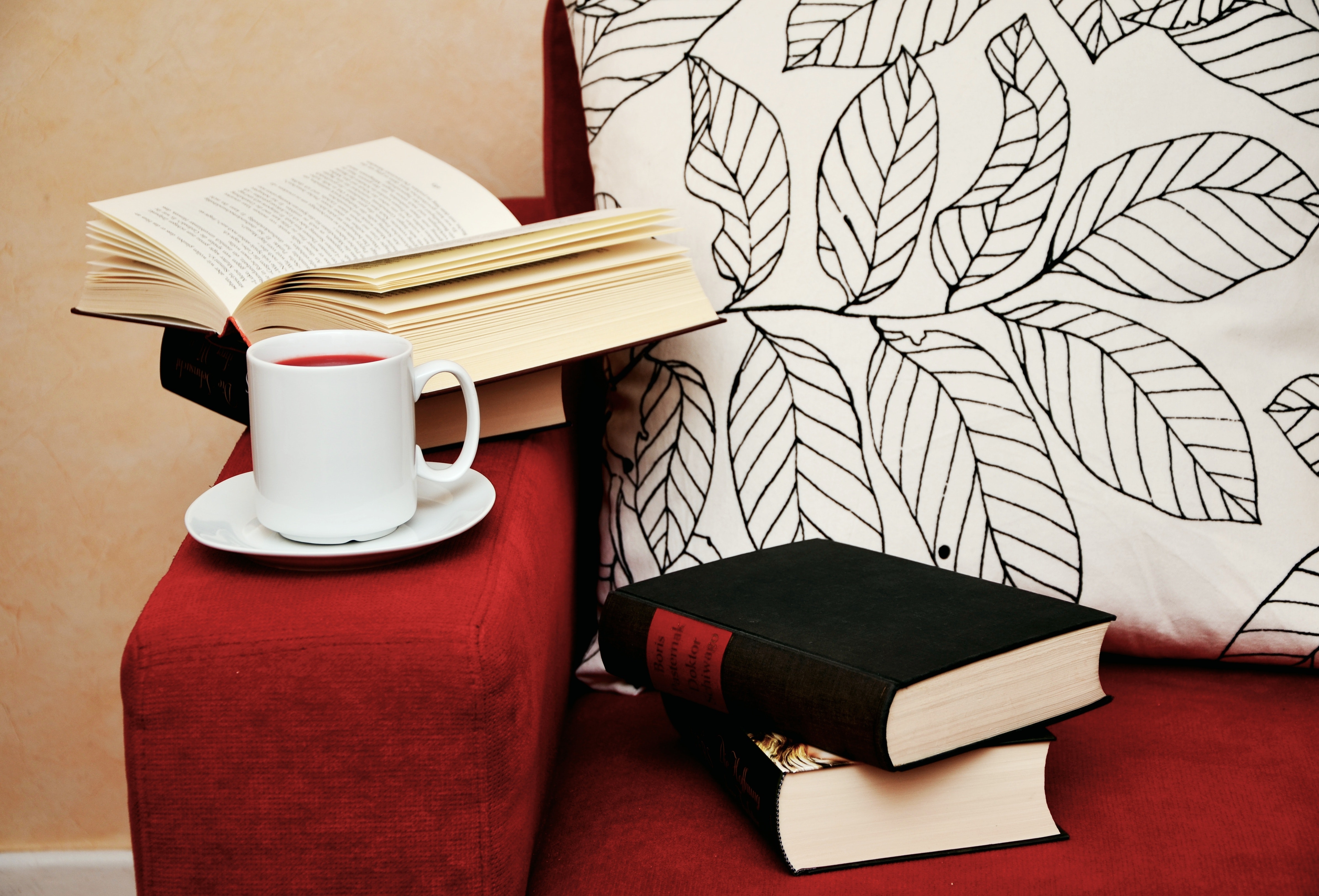 Plaatje van een stoel met boeken en een kopje koffie