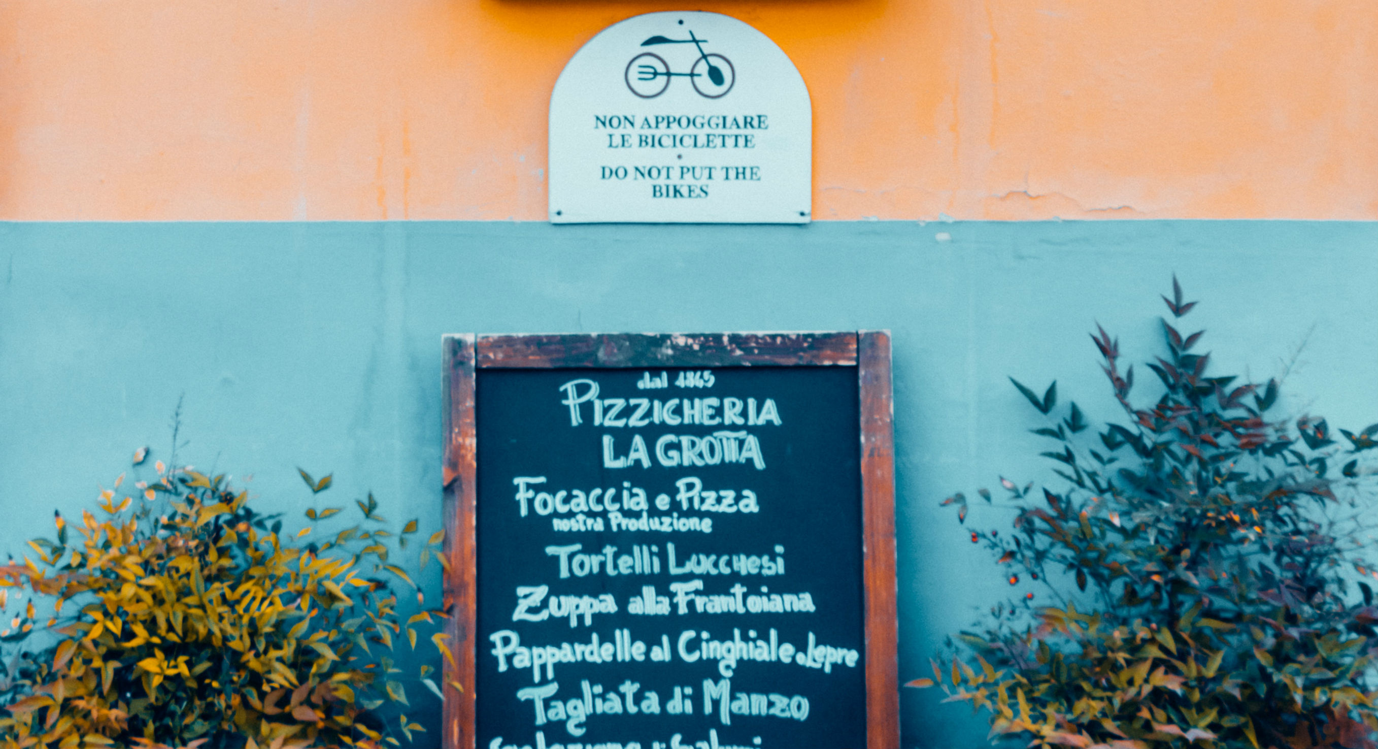 Italiaans straatje met menu van een pizzaria.