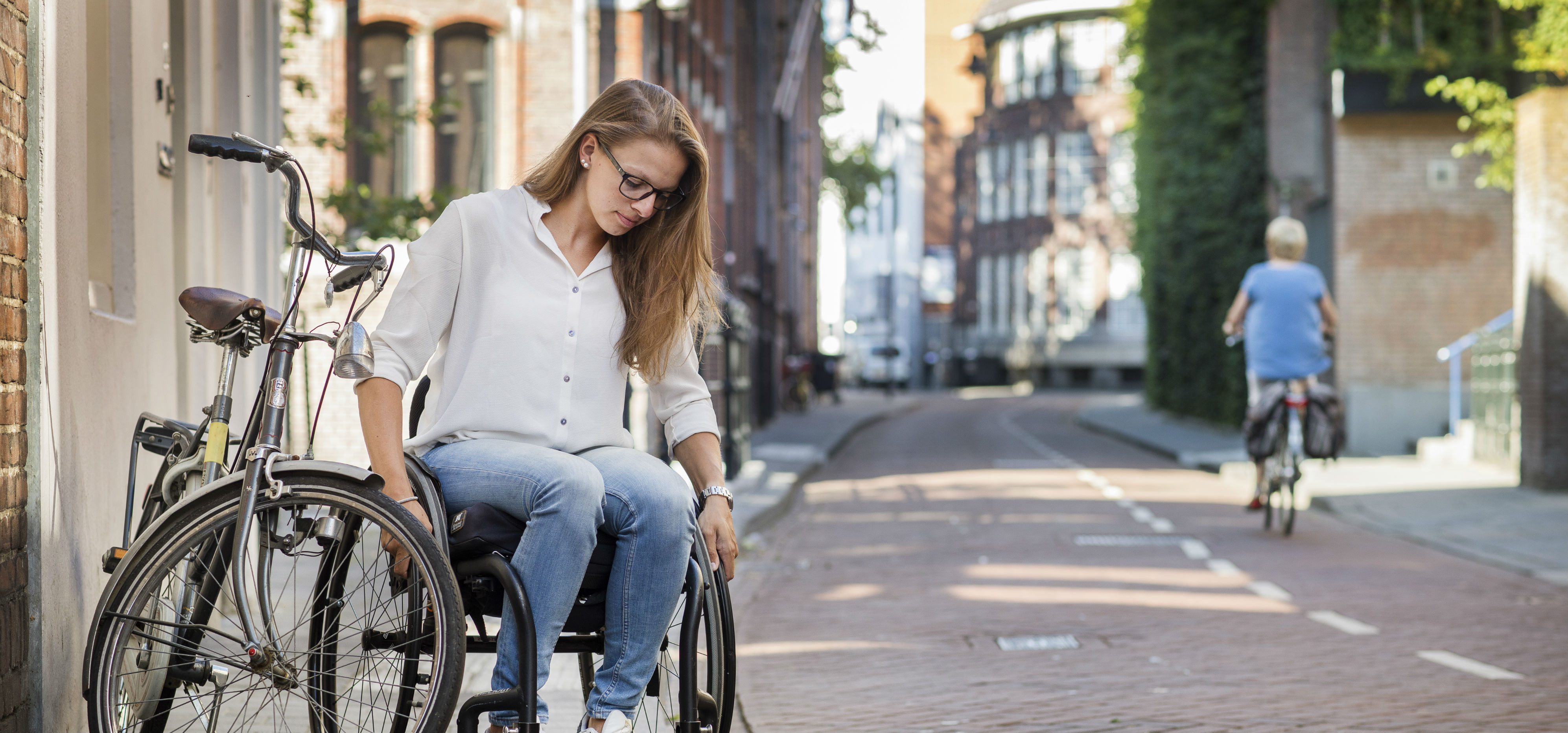 Wendi Schutte in een rolstoel probeert een stoeprand te trotseren.