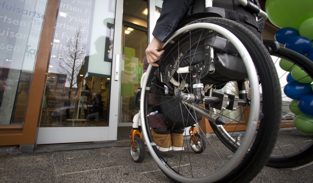 Iemand in rolstoel voor automatische schuifdeur