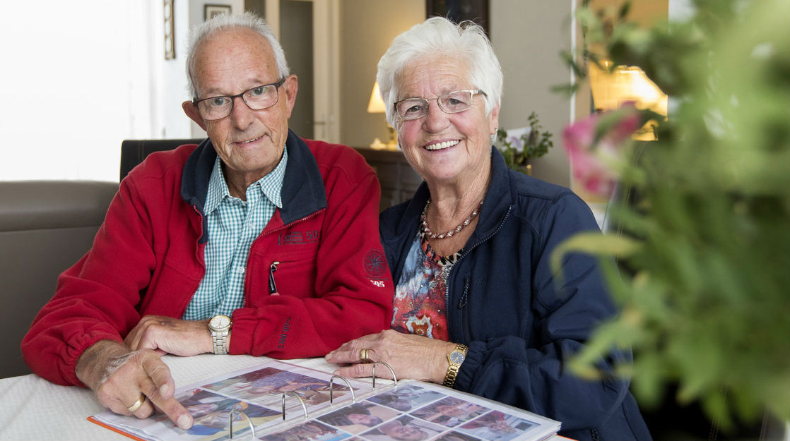 |Gerrie en Sjef bekijken foto's aan de koffietafel.
