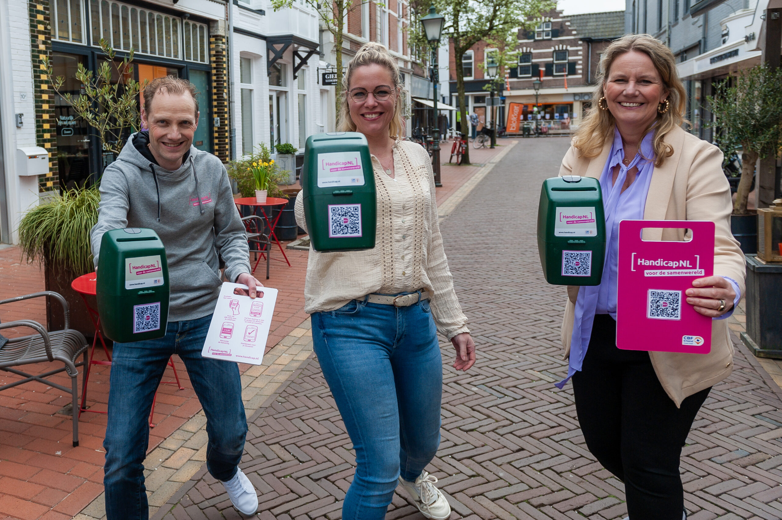 Het team van HandicapNL staat met collectebussen in een stad, ze staan actief met de collectebus voor zich uit